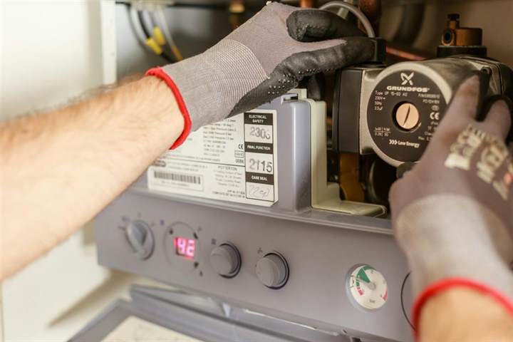 Technician servicing heating equipment